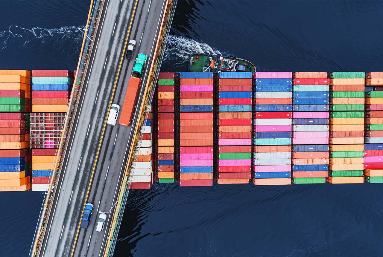 Shipping containers being transported under a bridge