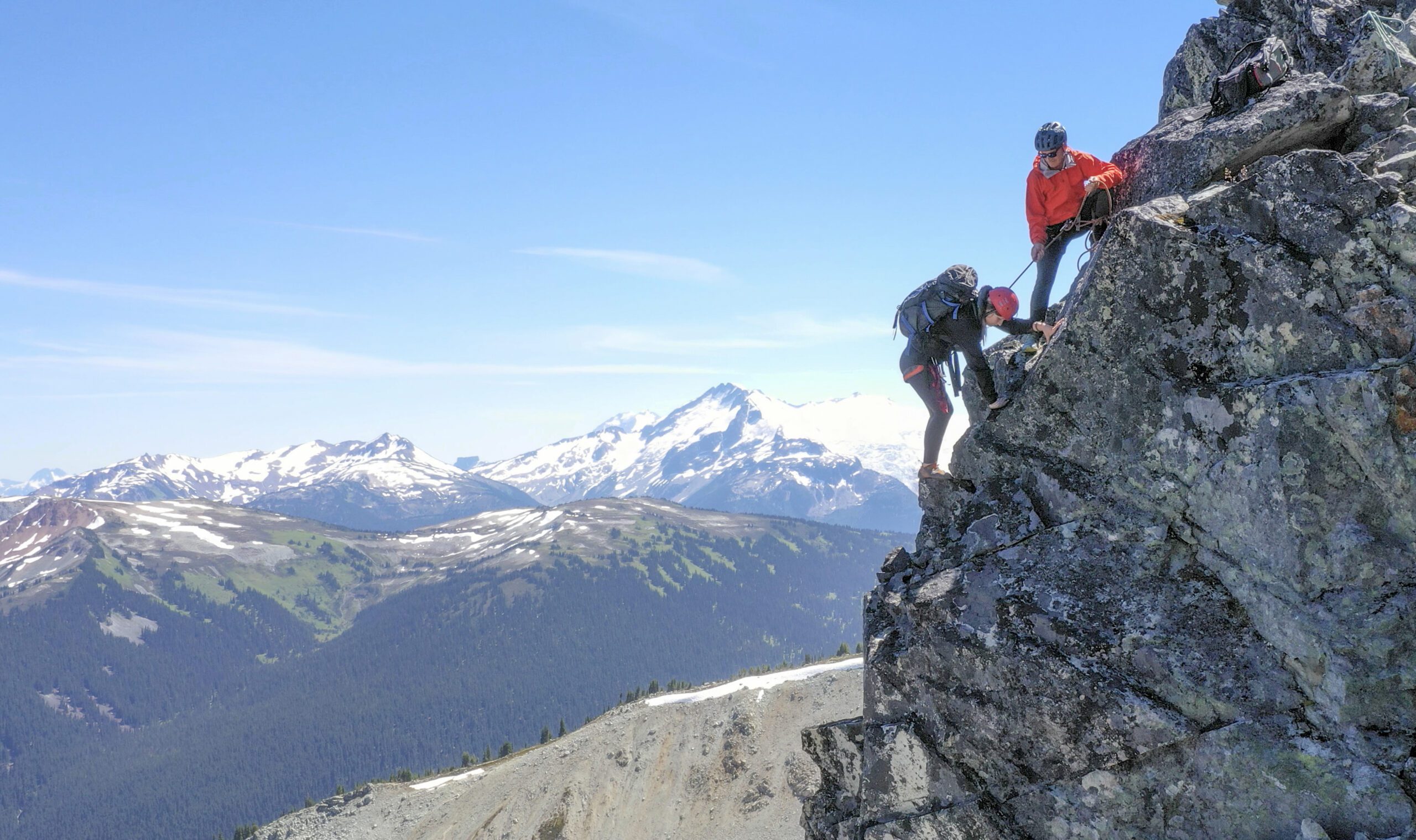 Female mountaineer climbs up mountain ridge