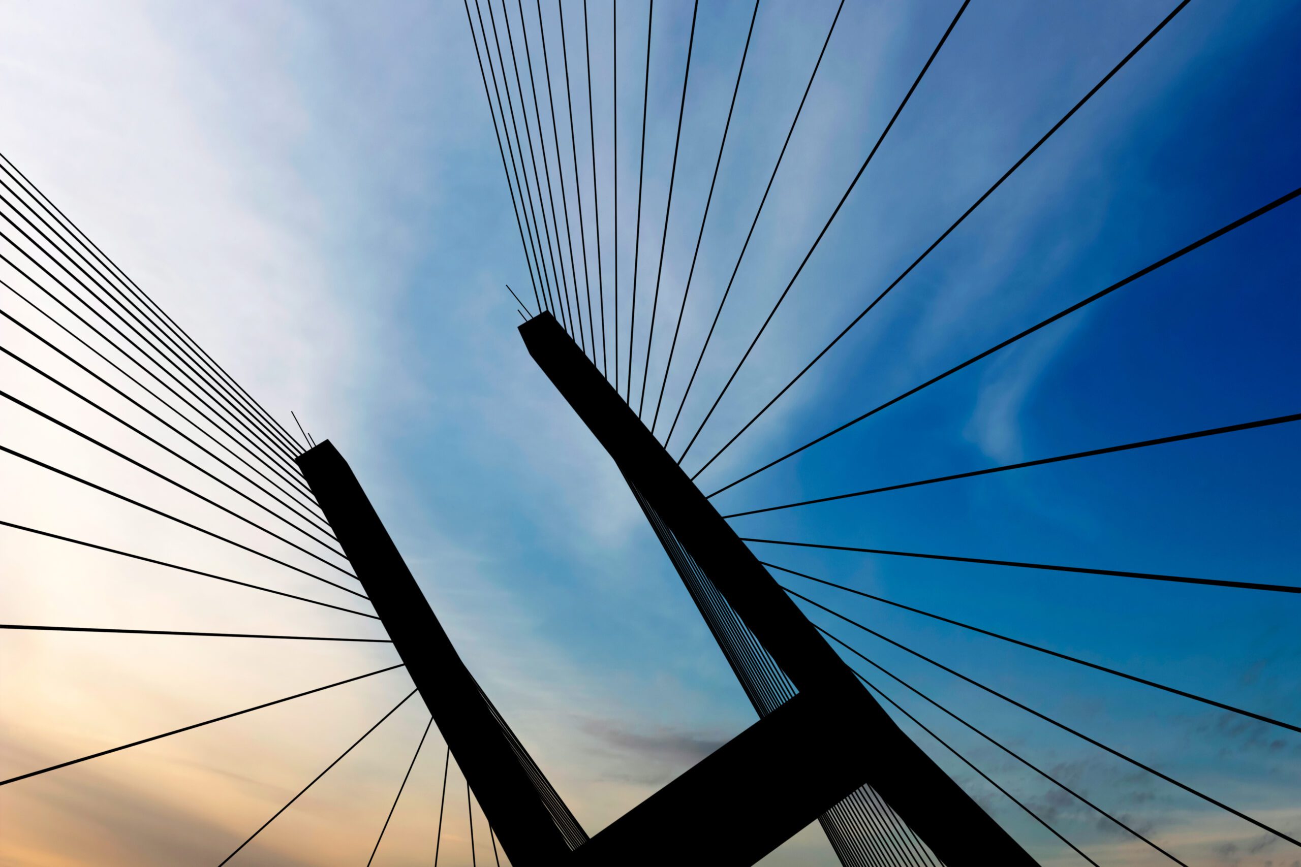 Suspension bridge tower in close-up silhouette at dusk