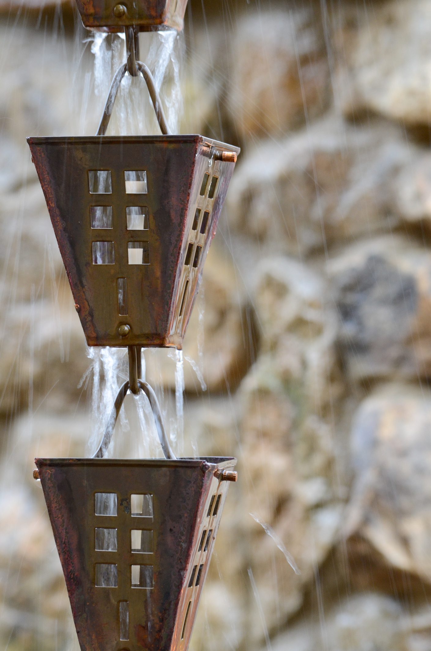 rain water flowing through rain chain down spout.