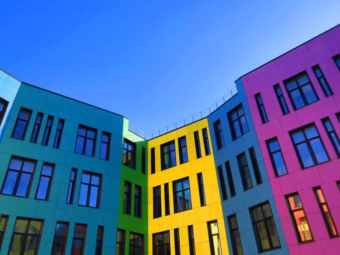 Multi-colored facades of the school with black window frames.