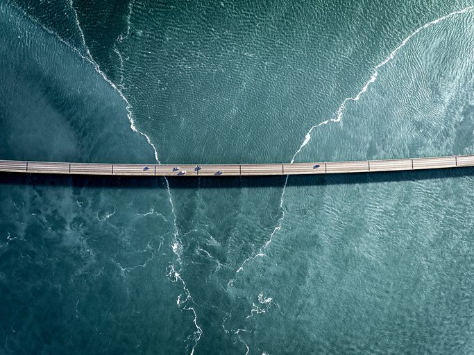 Driving on a bridge over deep blue water