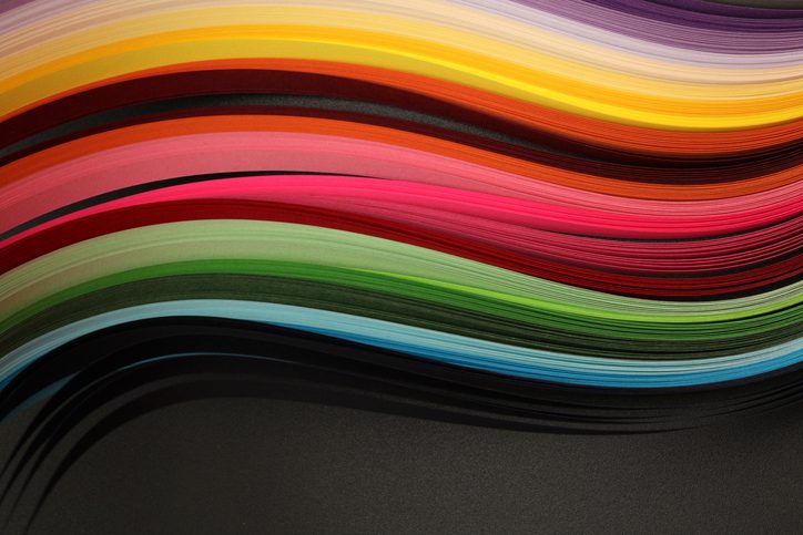 Abstract rainbow color wave paper on texture black horizontal background.