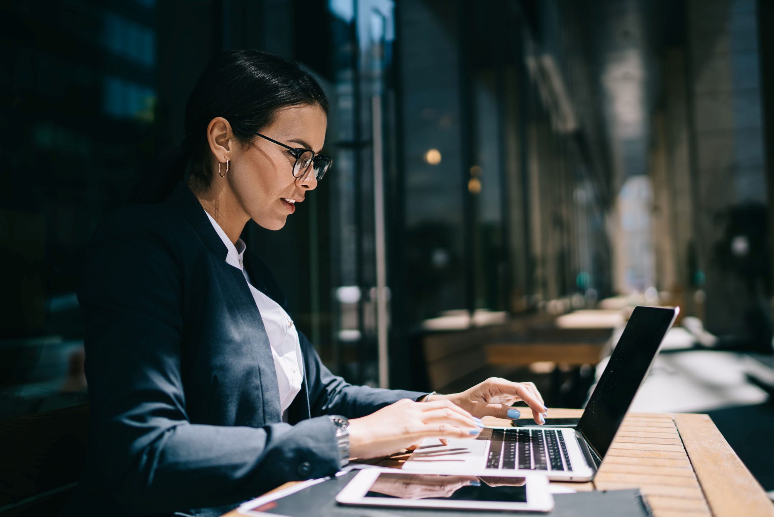 female exec working at laptop represents AML risk assessment