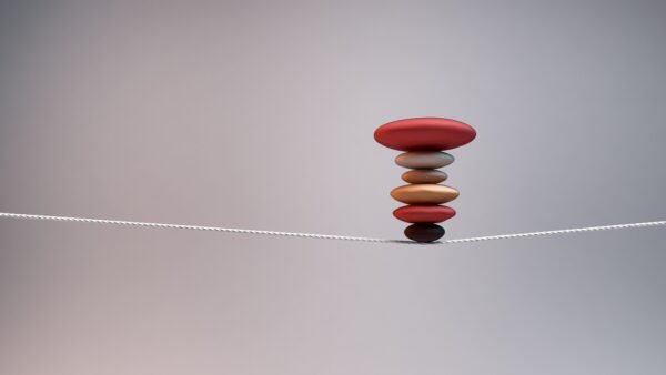 Colored rocks on a tightrope represent AI compliance strategies in wealth management